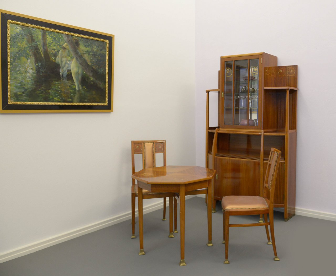 Hans Christiansen, Wohnzimmer-Ensemble (bestehend aus Tisch, zwei Stühlen und Vitrinenschrank, um 1900, Materialien: Mahagoniholz, Obstbaumholz, Perlmutt